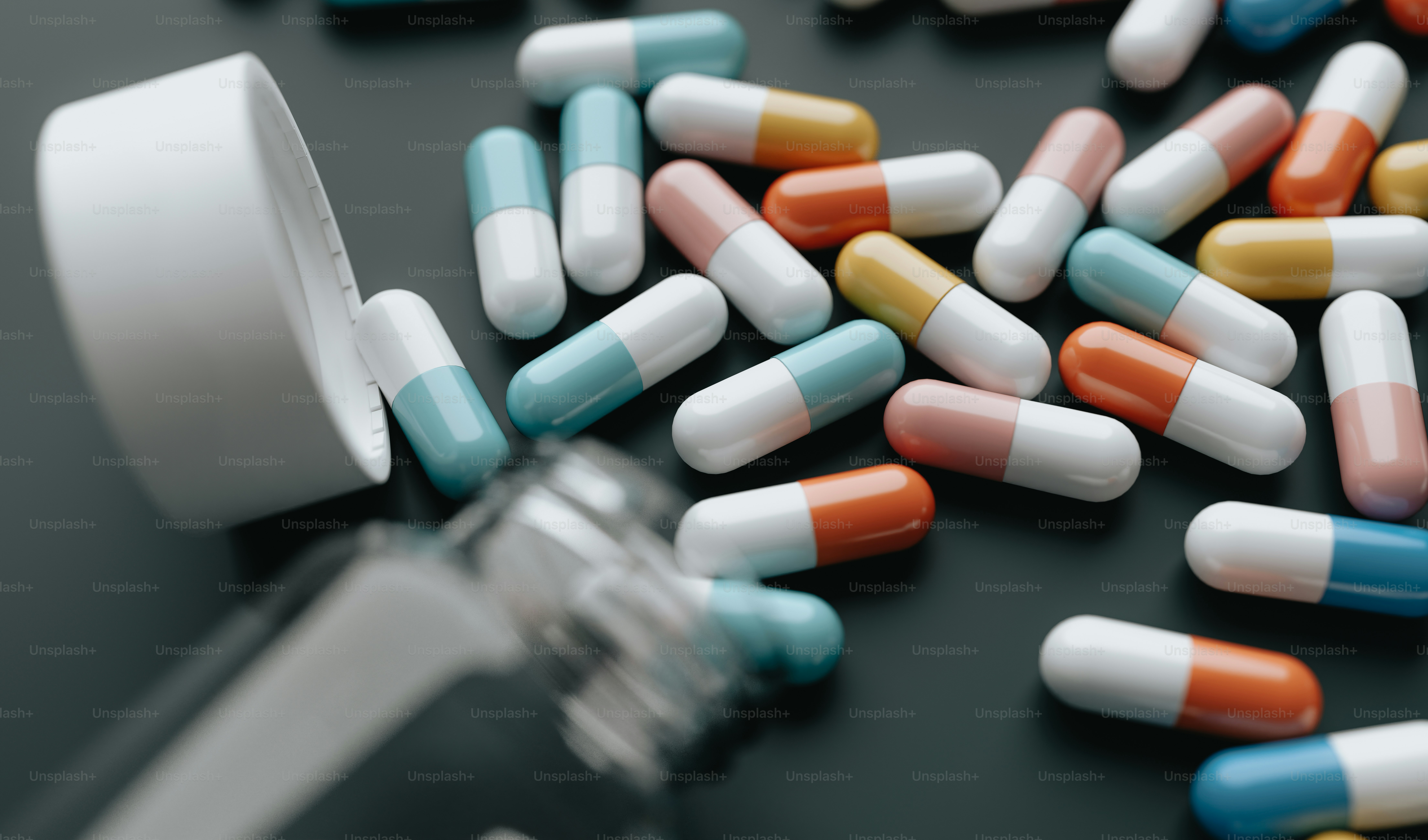 a close up of many pills and a glass of water